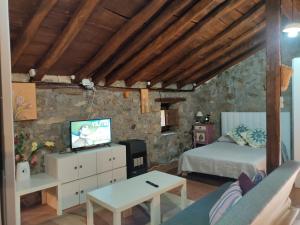 ValdicióLoma Bonita的一间卧室配有一张床,并在一间客房内配有电视。