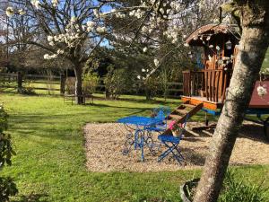 AblonROULOTTE CAPUCINE的一个带野餐桌和一棵树的游乐场