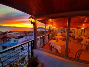 卢特拉艾季普苏Mitho Hotel Spa的一个带桌椅的阳台,享有日落美景