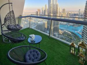 迪拜FIRST CLASS 3BR with full BURJ KHALIFA and FOUNTAIN VIEW的阳台配有桌椅,享有城市美景。