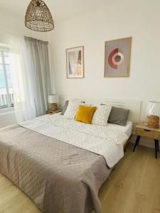 卡尔佩Apartament Mariola的白色卧室配有一张带黄色枕头的大床
