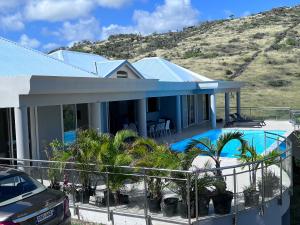 圣马丁岛Villa Taïana的一座带游泳池和山丘的房屋