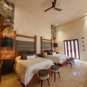 巴利亚多利德Oriundo Luxury Nature Villas的一间卧室设有两张床和石墙