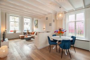 阿尔克马尔CASASdeCASPER - Apartment Alkmaar的客厅配有桌子和蓝色椅子