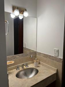 拉法尔达Uptown City Apart La Falda的一间带水槽和大镜子的浴室