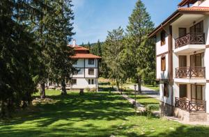 斯莫梁Утро без Аларма, Смолянски езера. Alarm free Morning Smolyan lakes的一座公寓楼,有树木庭院