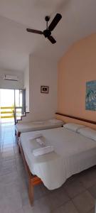 康塞桑达巴拉太阳花旅馆的一间带三张床和吊扇的卧室
