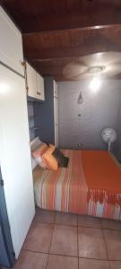 希伯丁Anchor Aweigh Chalet 86的一间小卧室,配有带橙色床单的床