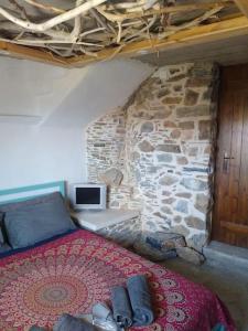 KeramesThe Village House的一间卧室设有一张床和石墙
