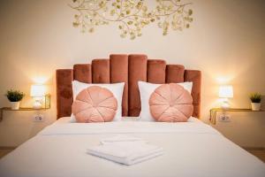 康斯坦察Apartament Zafi Lakeview的卧室配有一张带粉红色枕头的大床