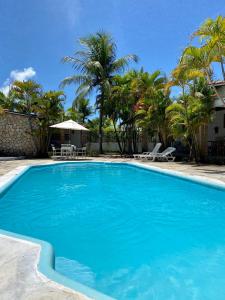 圣若泽-达科罗阿格兰迪Village do Sossego的一座拥有蓝色海水和棕榈树的游泳池
