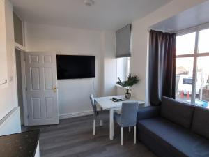 布莱克浦Granada Apartments Queen's Promenade的客厅配有沙发和桌子