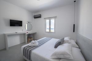 卡马利Kamara Sea View Villa的白色卧室配有床和书桌
