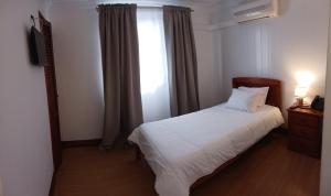 蓬塔德尔加达Hotel Insular的卧室配有白色的床和窗户。