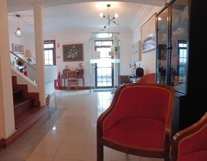 蓬塔德尔加达Hotel Insular的一间带红色椅子和楼梯的客厅