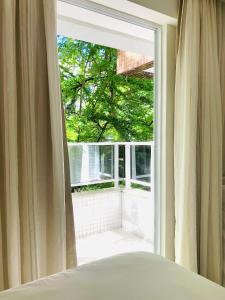 若昂佩索阿Tambaú Home Beira Mar - com varanda的卧室设有窗户,享有树木美景