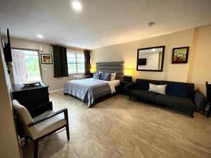 达尼亚滩谢里登公寓式酒店的一间卧室配有一张床和一个沙发