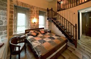 阿卡埃克泰尔精品酒店的一间带一张床的卧室,位于带楼梯的房间