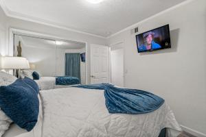 坦帕Wake up to Ocean Views from your private balcony的卧室配有一张床和壁挂式平面电视。