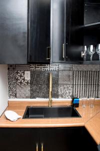 伊斯米基尔潘Rá Ngu的厨房配有水槽和黑色橱柜