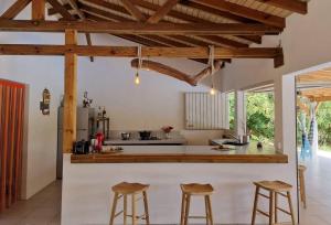 BeauséjourKazacactus-villa 3 chambres piscine Marie-Galante的厨房设有木制天花板和带凳子的台面。
