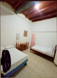 圣埃莱纳Hospederia Oasis的一间卧室配有两张床和一张桌子及椅子