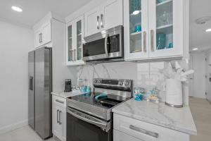坦帕Welcome to Sea Forever - Balcony Water View Tampa的厨房配有白色橱柜和炉灶烤箱。