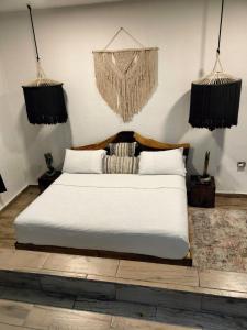 科苏梅尔San MARTÍN的卧室配有白色的床和2个挂篮