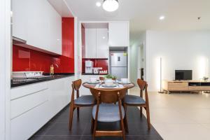 吉隆坡Netflix 1-4pax Family Suite at Arcoris Mont Kiara的红色和白色的厨房配有桌椅