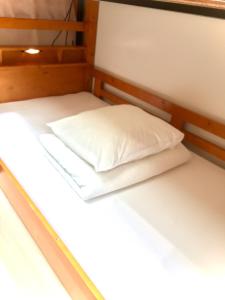 大阪Guest House Kirara - Vacation STAY 88539的一张位于房间的床,上面有两个枕头
