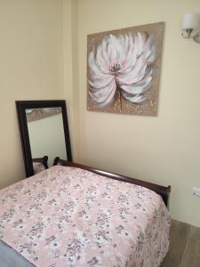 格罗斯岛Belle Cove的卧室配有一张挂有花卉画的床铺。