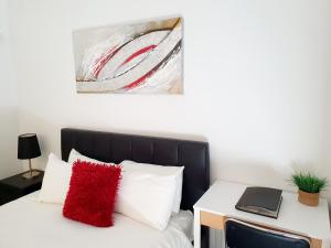 珀斯M5 West Perth Studio Apartment near Kings Park的一间卧室配有一张红色枕头的床