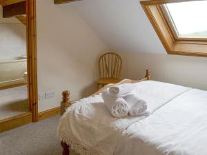 Rosedale Abbey科比伍德乡村别墅的一间卧室配有一张带白色床单的床和一扇窗户。