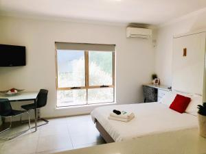 珀斯M4 West Perth Studio Apartment near Kings Park的一间卧室配有一张床、一张书桌和一个窗户。