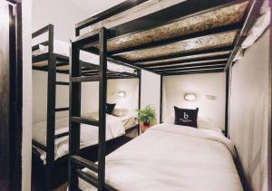清迈BLOOMZ HOSTEL的卧室配有2张双层床和白色床单