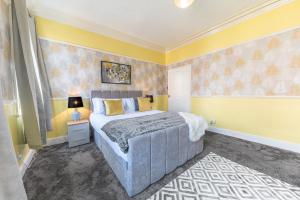 巴罗弗内斯Stylish Luxury Large 4BR KingBed的一间卧室设有一张床和黄色的墙壁
