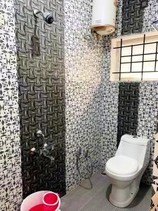 科代卡纳尔Kalyani Homestay的浴室设有卫生间,铺有黑白瓷砖。