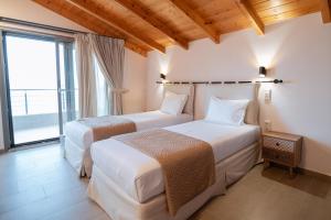 普雷韦扎Sofita με θέα τη θάλασσα Villa Athina的带大窗户的客房内的两张床