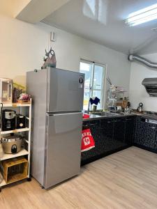 成功镇鰆居Chun House 三仙台的一间厨房,里面配有不锈钢冰箱