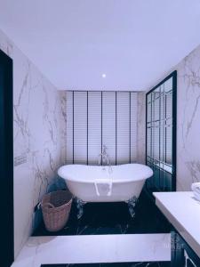清迈ห้องดีลักซ์วิวดอยสุเทพ Deluxe with Doi Suthep view的带窗户的浴室内的白色浴缸