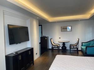 清迈ห้องดีลักซ์วิวดอยสุเทพ Deluxe with Doi Suthep view的一间卧室配有一张床、一张桌子和一台电视