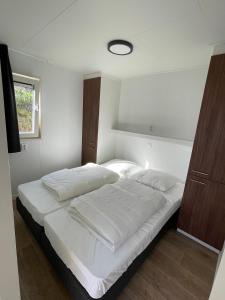 艾默伊登Zee en duin的一间卧室配有一张带白色床单的大床