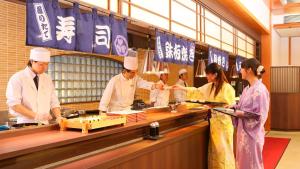 会津若松Ooedo Onsen Monogatari Higashiyama Grand Hotel的一群厨师在厨房里准备食物