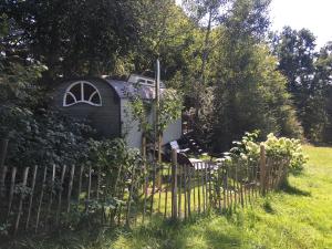 Fischachhistorischer Zirkuswagen inmitten der Natur的院子中的小房子,有栅栏