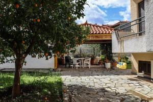 波利蒂卡Nice house in Euboea的庭院里种植着橘子树,配有桌椅