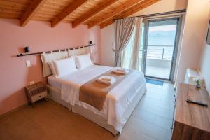 普雷韦扎Villa Athina的一间卧室设有一张大床和大窗户