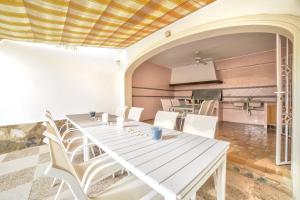 卡尔佩Villa Garrofer - PlusHolidays的一间设有白色桌子和白色椅子的用餐室
