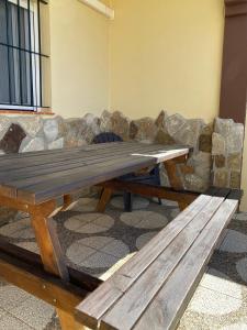 博罗尼亚Apartamentos Turísticos Carmencita的石头沙发前的木餐桌