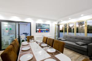 阿德耶Luxury Apartment的一间带桌子和沙发的用餐室