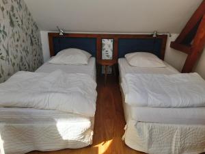Saint-Julien-de-la-LiègueLe Clos du Buisson的小客房内的两张床,配有白色床单